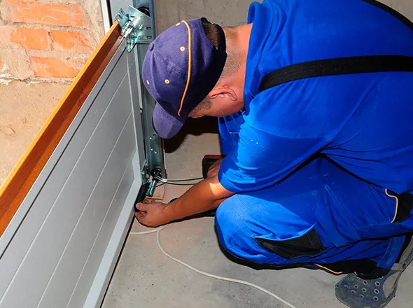 The technician is repairing the garage door to make sure it works safely.