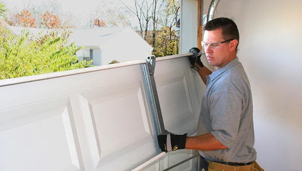 Professional garage door installation being performed to enhance home look.