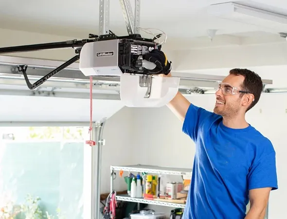 Worker setting up a garage door opener in a home garage.