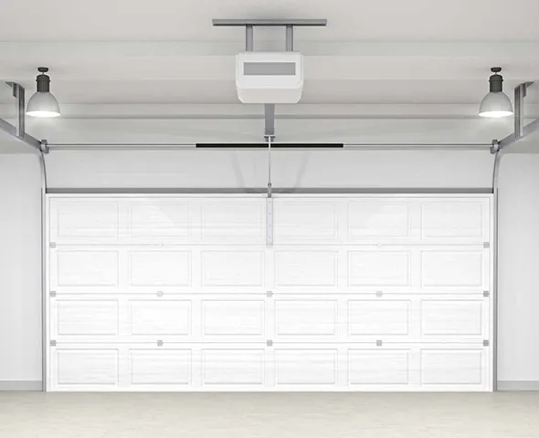 Inside a garage with a garage door opener, bright lights, and a smooth white door.