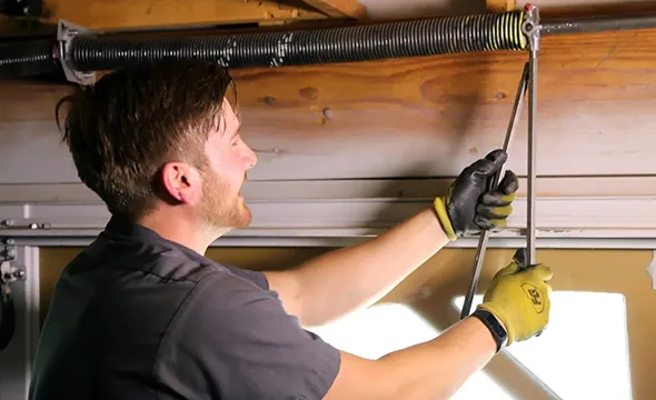 Worker fixes a garage door spring.